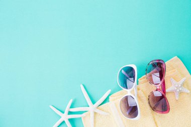 Yaz tatili ve tatil konsepti için parlak pastel yeşil arka plan plaj aksesuarları denizyıldızı plaj şapkası ve deniz kabuğu üst görünümü. Düz yatıyordu.