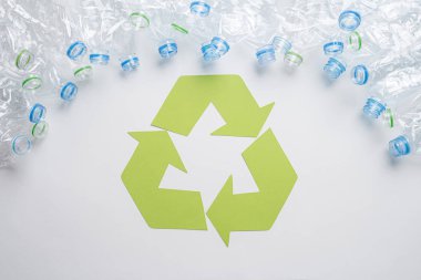 Ahşap arka plan üzerinde geri dönüşüm sembolü ile kullanılan plastik şişe çerçeve. Geri dönüşüm konsepti