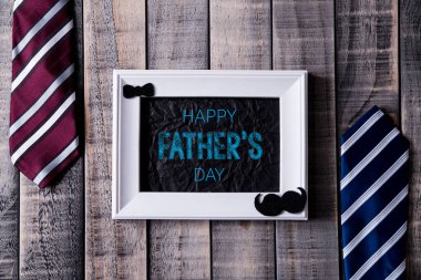 Mutlu babalar günü kavramı. Koyu ahşap masa arka planı üzerinde mavi ve kırmızı kravatkenarlı beyaz resim çerçevesinin üst görünümü. Düz yatıyordu.