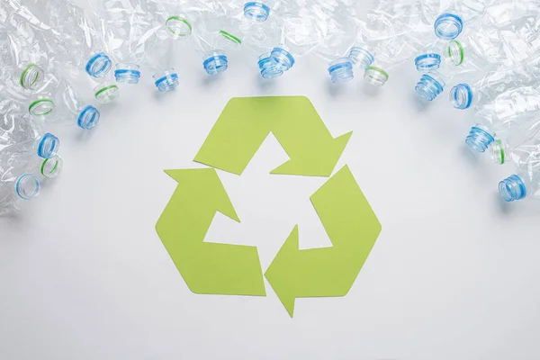 Rama zużytych plastikowych butelek z symbolem recyklingu na drewnianym tle. Koncepcja recyklingu — Zdjęcie stockowe