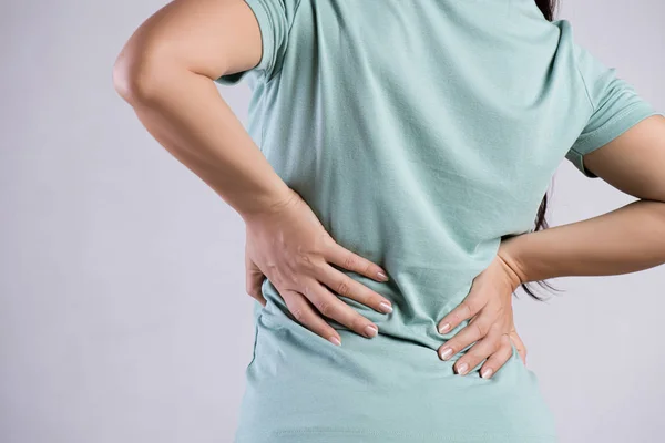 Крупним планом жінка має біль у пошкоджених спинах. Концепція охорони здоров'я та болю в спині . — стокове фото
