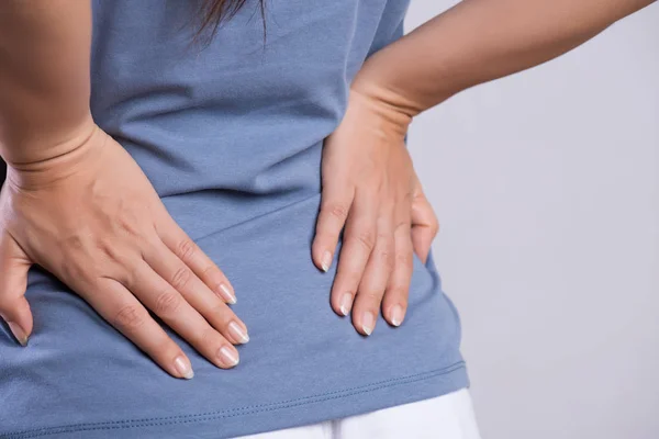 Крупним планом жінка має біль у пошкоджених спинах. Концепція охорони здоров'я та болю в спині . — стокове фото