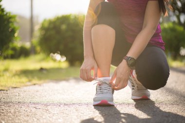 Ayakkabı - ayakkabı bağcıklarımı ipe kadın closeup çalıştırıyor. Kadın spor fitness runner Bahçe arka planda koşu için hazırlanıyor.