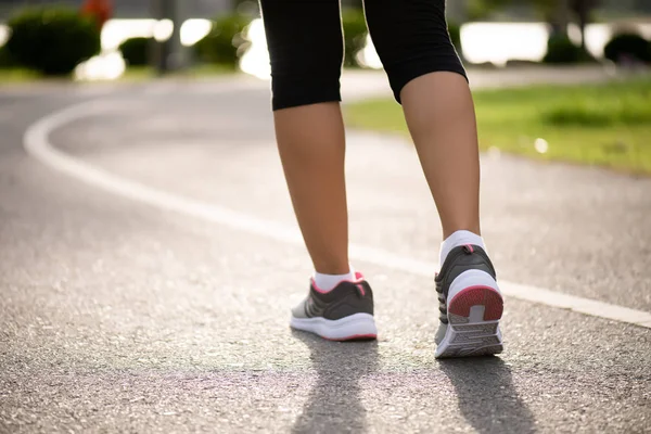 Mujer de primer plano caminando hacia el lado de la carretera. Concepto de actividades de paso, paseo y ejercicio al aire libre . — Foto de Stock