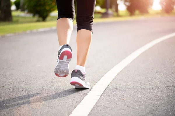 Mujer de cerca corriendo hacia el lado de la carretera. Concepto de actividades de ejercicio de paso, carrera y al aire libre . — Foto de Stock