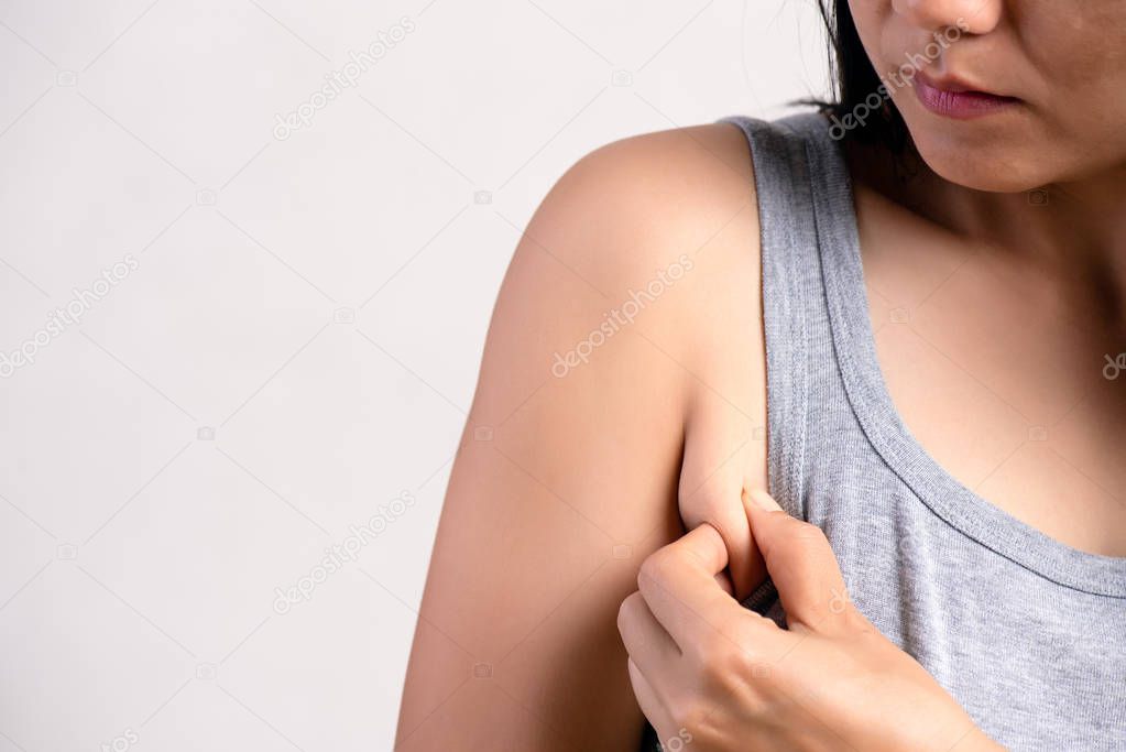 Close up woman pulling her skin underarm. problem armpit fat skin concept.