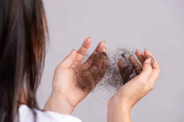Concepto saludable. Mujer mostrar su cabello dañado pérdida larga y mirando su pelo en la mano . — Foto de Stock