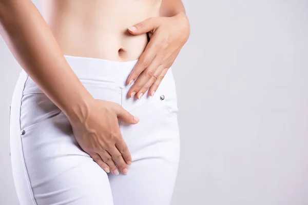 Ung kvinna med smärtsamma magont med händer som håller att trycka hennes grenen nedre delen av buken. Medicinska och gynekologiska problem, hälso-och koncept — Stockfoto