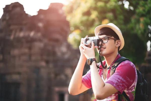 Jeune homme photographe Voyageur avec sac à dos prenant des photos avec son appareil photo, Grand mur en arrière-plan à l'endroit historique. Style de vie et concept de voyage . — Photo