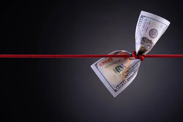 American dollar tied up in red rope knot on dark background with copy space. business finances, savings and bankruptcy concept. Royalty Free Stock Photos