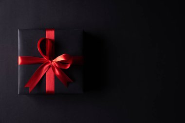 Metin için kopya alanı ile siyah arka plan üzerinde kırmızı şeritli siyah noel kutuları üst görünümü. kara Cuma kompozisyon.