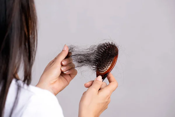 Concepto saludable. Mujer mostrar su cepillo con el pelo dañado de pérdida larga y mirando su cabello . — Foto de Stock