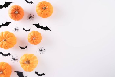 Cadılar Bayramı el sanatları, turuncu balkabağı, hayalet, yarasa ve örümceğin beyaz arkaplandaki görüntüsü ve metin için kopya alanı. Cadılar Bayramı konsepti.