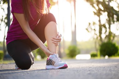 Ayak bileği burkuldu. Genç kadın egzersiz çalışırken bir bilek yaralanma acı. Sağlık ve spor kavramı.