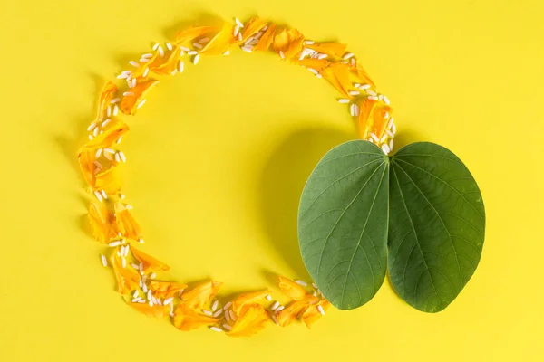 Šťastné Dussehra. Žluté květiny, zelený list a rýže na žlutém pozadí. Koncepce indického festivalu dušsehra. — Stock fotografie