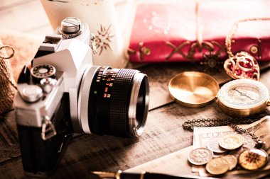 vintage öğeler, kalem kırmızı kitap, sikke para, pusula ve ahşap arka plan üzerinde retro fotoğraf filmi kamera.