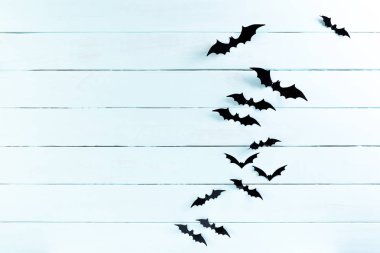Halloween el sanatları üst görünümü, metin için kopya alanı ile mavi pastel ahşap arka plan üzerinde uçan siyah kağıt yarasalar. cadılar bayramı kavramı.