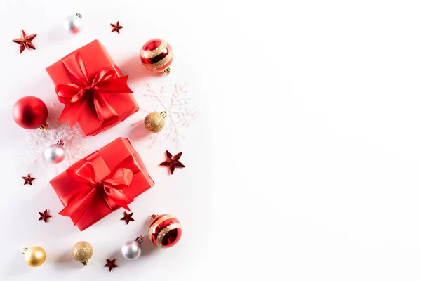 Η ιδέα του χριστουγεννιάτικου παρελθόντος. Κορυφαία θέα του Χριστουγεννιάτικο κουτί δώρου με καραμέλα ζαχαροκάλαμο, χιονονιφάδες, κόκκινα μούρα και καμπάνα σε λευκό ξύλινο φόντο. — Φωτογραφία Αρχείου
