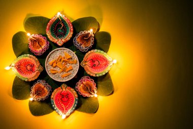 Mutlu Dussehra. Kil Diya lambalar sarı çiçekler, yeşil yaprak ve sarı pastel arka plan üzerinde pirinç ile Dussehra sırasında yaktı. Dussehra Hint Festivali konsepti.