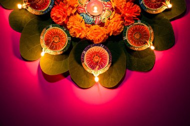 Mutlu Dussehra. Kil Diya lambalar sarı çiçekler, yeşil yaprak ve pembe pastel arka plan üzerinde pirinç ile Dussehra sırasında yaktı. Dussehra Hint Festivali konsepti.