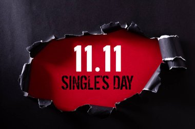 Çin online alışveriş, 11.11 tek gün satış konsepti. Siyah yırtık kağıt ve metin 11.11 kırmızı bir arka plan üzerinde tek gün satış üst görünümü.