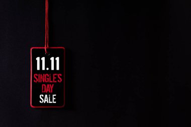 Çin online alışveriş, 11.11 tek gün satış konsepti. Siyah ve kırmızı kağıt etiketinin siyah arka plan üzerinde 11.11 tekli gün satışı ile üst görünümü.
