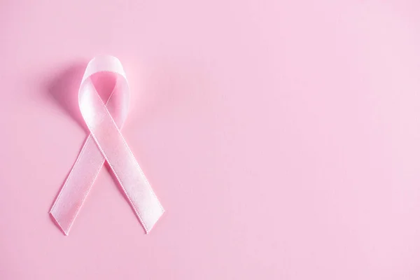 Cinta rosa sobre fondo de papel pastel rosa para apoyar la campaña del mes de concienciación sobre el cáncer de mama. — Foto de Stock