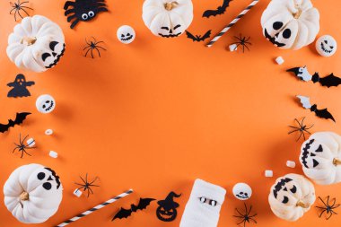 Metin için kopya alanı ile turuncu arka plan üzerinde Halloween el sanatları, turuncu kabak, hayalet, yarasa ve örümcek üst görünümü. cadılar bayramı kavramı.