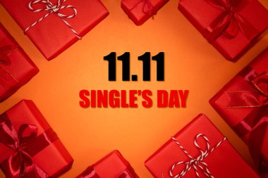 Çin online alışveriş, 11.11 tek gün satış konsepti. Metin 11.11 tek gün satış için kopya alanı ile kırmızı ve turuncu arka plan üzerinde kırmızı kurdele ile noel kutuları üst görünümü.