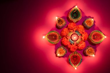 Mutlu Diwaliler - Dipavali sırasında Clay Diya lambaları yandı, Hindu ışık festivali kutlaması. Pembe arka planda renkli geleneksel gaz lambası diya