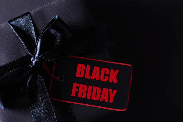 Draufsicht auf schwarze Weihnachtsboxen mit rotem Papieranhänger auf schwarzem Hintergrund mit Kopierraum für Text. Black-Friday-Komposition. — Stockfoto