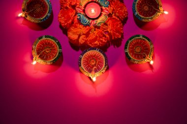 Mutlu Diwaliler - Dipavali sırasında Clay Diya lambaları yandı, Hindu ışık festivali kutlaması. Pembe arka planda renkli geleneksel gaz lambası diya