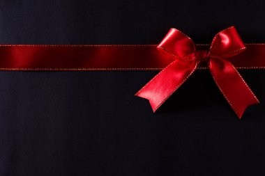 Siyah arkaplandaki kırmızı kurdelenin üst görünümü ve metin için kopyalama alanı. Kara Cuma ve Boks Günü kompozisyonu.