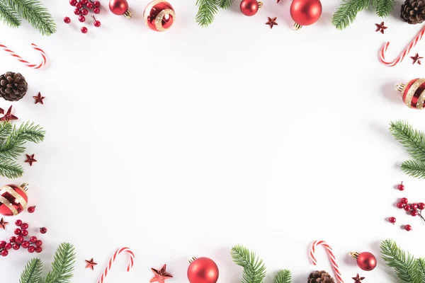 Концепция Рождества. Вид сверху на рождественскую зеленую подарочную коробку со свечной тростью, снежками, красными ягодами и колокольчиком на белом деревянном фоне . — стоковое фото