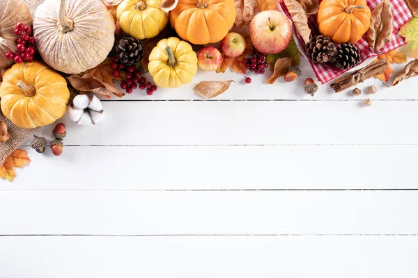Ansicht von Herbst-Ahornblättern mit Kürbis und roten Beeren auf weißem Holzhintergrund. Konzept zum Erntedankfest. — Stockfoto