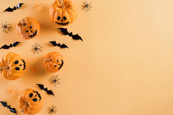 Vista superior de manualidades de Halloween, calabaza naranja, fantasma blanco, murciélago y araña sobre fondo naranja con espacio de copia para el texto. concepto de Halloween. — Foto de Stock