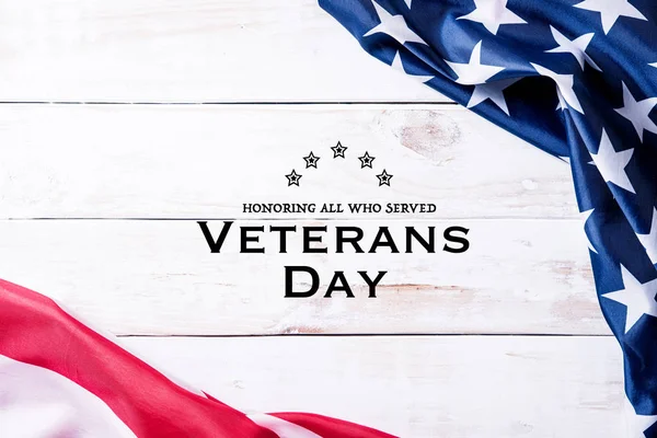 Gaziler Günün kutlu olsun. Amerika Birleşik Devletleri bayraklarının en üst görüntüsü beyaz ahşap arka plandaki gazilere teşekkür metniyle. 11 Kasım.