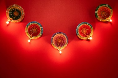 Mutlu Diwaliler - Dipavali sırasında Clay Diya lambaları yandı, Hindu ışık festivali kutlaması. Pembe arka planda renkli geleneksel gaz lambası diya