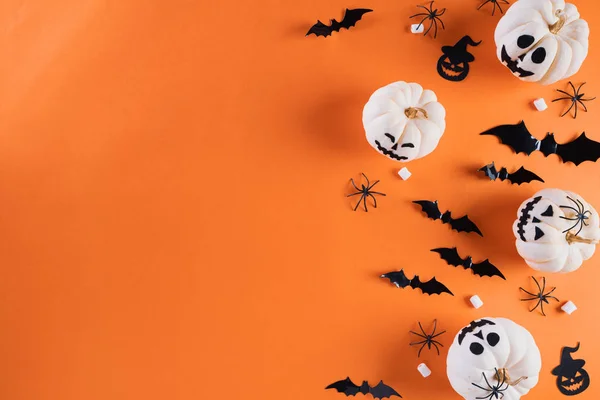 ハロウィーンの工芸品、白いカボチャ、幽霊、コウモリとテキストのためのコピースペースとオレンジ色の背景にクモのトップビュー。ハロウィーンのコンセプト. — ストック写真
