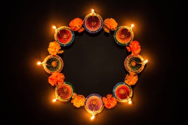 Mutlu Diwaliler - Dipavali sırasında Clay Diya lambaları yandı, Hindu ışık festivali kutlaması. Siyah arka planda renkli geleneksel gaz lambası diya