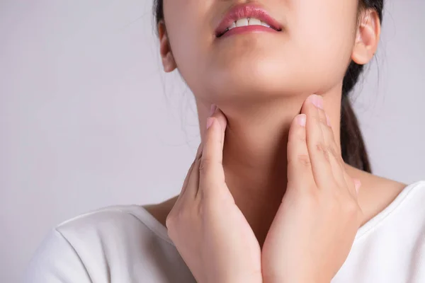 Halsschmerzen. Nahaufnahme der schönen jungen Frau Hand, die ihren kranken Hals berührt. Gesundheitswesen und medizinisches Konzept. — Stockfoto