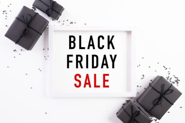 Siyah Cuma indirimli metnin beyaz çerçeveli, siyah hediye kutulu ve beyaz arka planda Noel balosu ve böğürtlenli hali. Alışveriş konsepti ve Kara Cuma kompozisyonu.