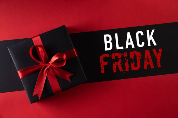Top view of black christmas boxes with red ribbon on black background with copy space for text. black Friday and Boxing Day composition. — Stock Photo, Image