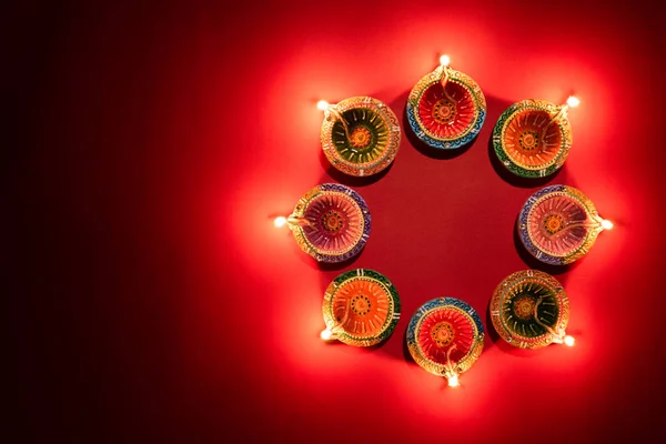 Happy Diwali - Clay Diya lâmpadas acesas durante Dipavali, festival hindu de luzes celebração. Lâmpada de óleo tradicional colorido diya no fundo rosa — Fotografia de Stock