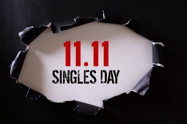 Çin 'de online alışveriş, 11.11 bekarlar günü konsepti. Siyah yırtık kağıdın üst görüntüsü ve beyaz arka planda 11.11 tekler günü indirimi.