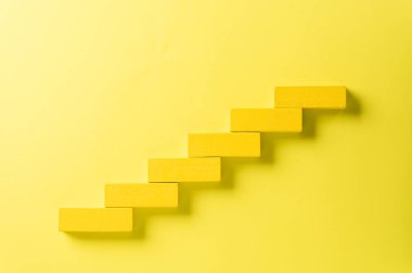 Başarı temeli konsepti. Sarı tahta blok basamak olarak dizilme, iş büyüme konsepti siyah zemin üzerinde başarı.