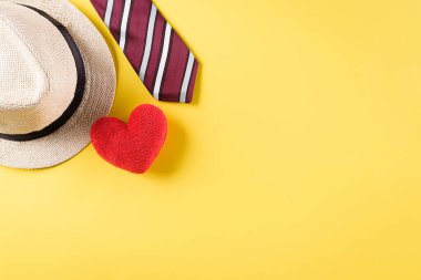 Renkli kravatlı, kırmızı kalpli ve pastel sarısı şapkalı Babalar Gününüz kutlu olsun. Üst Görünüm, Boşluğu Kopyala.