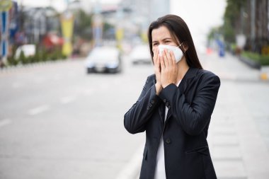 Koruyucu yüz maskesi takan ve öksüren bir iş kadınının etrafını sarın. Coronavirus ve 2.5..