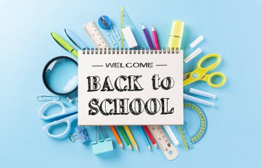 Eğitim ya da okula dönüş konsepti. Renkli okul gereçleri, kitaplar, renkli kalemler, hesap makinesi, ataçlar ve pastel kağıt üzerine elma. Düz yatıyordu.