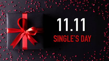 Çin 'de online alışveriş, 11.11 bekarlar günü konsepti. Siyah arkaplanda kırmızı kurdeleli siyah noel kutularının üst görünümü metin 11: 11 tekler için kopya alanı.